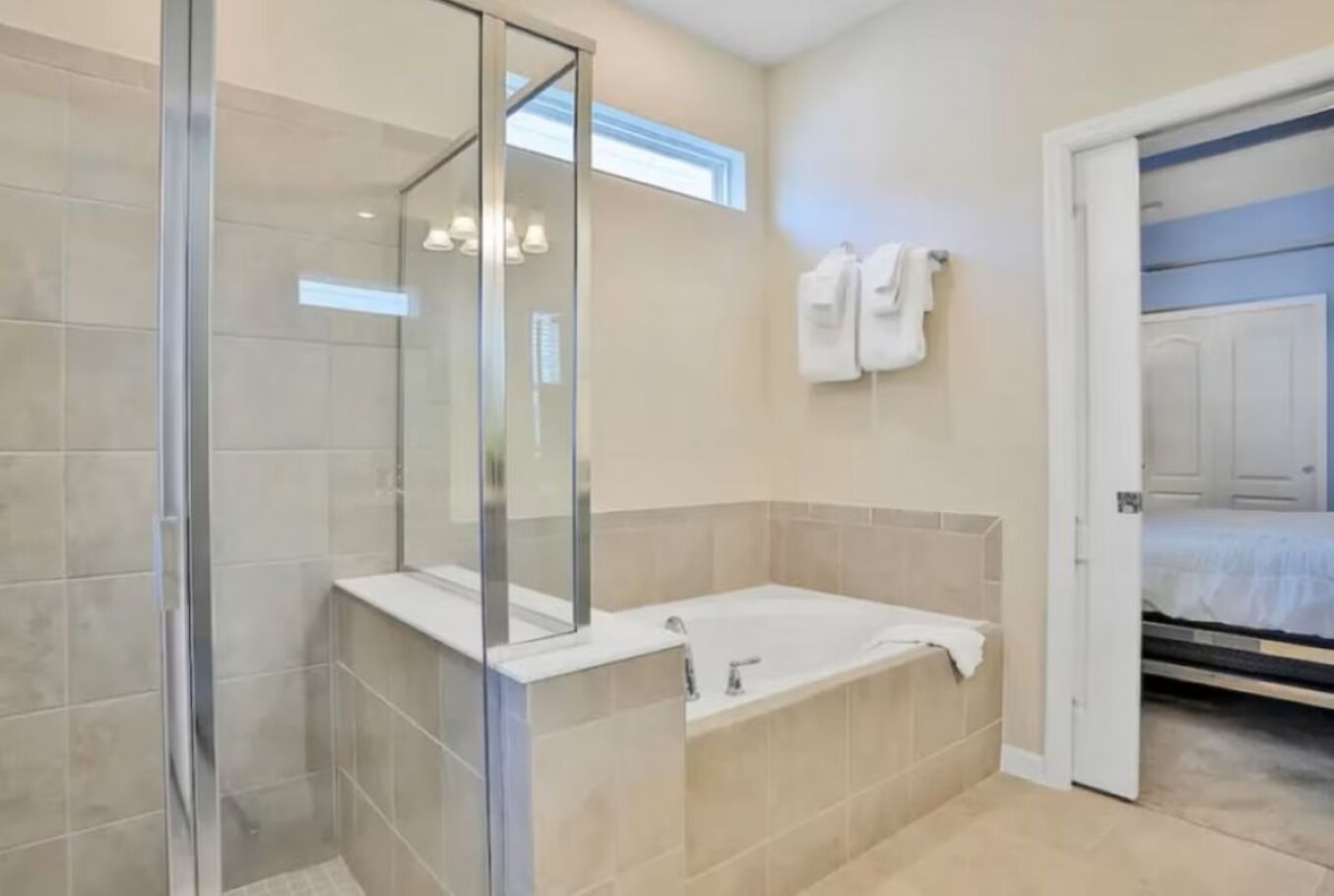 A modern bathroom with a glass shower enclosure, a freestanding bathtub, and a walk-in shower.