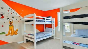 A room with bunk beds, a wall mural, and a window.