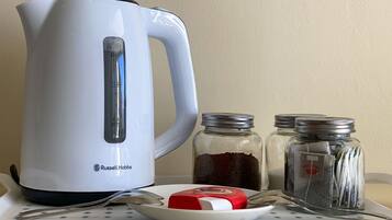 En vit vattenkokare från Russell Hobbs, två glasburkar med metallock och en vit tallrik med ett rött och vitt föremål på.