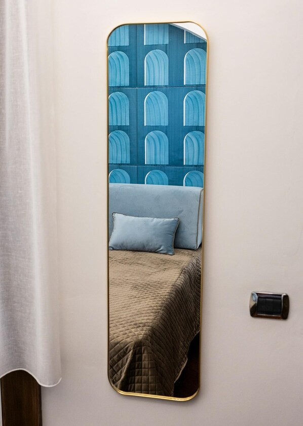 A bed with a quilted brown cover, two pillows, and a blue patterned headboard. - B&B Boutique Epoca (Salerno)