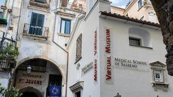 A building with a sign for the Virtual Museum of the Medical School of Salerno.