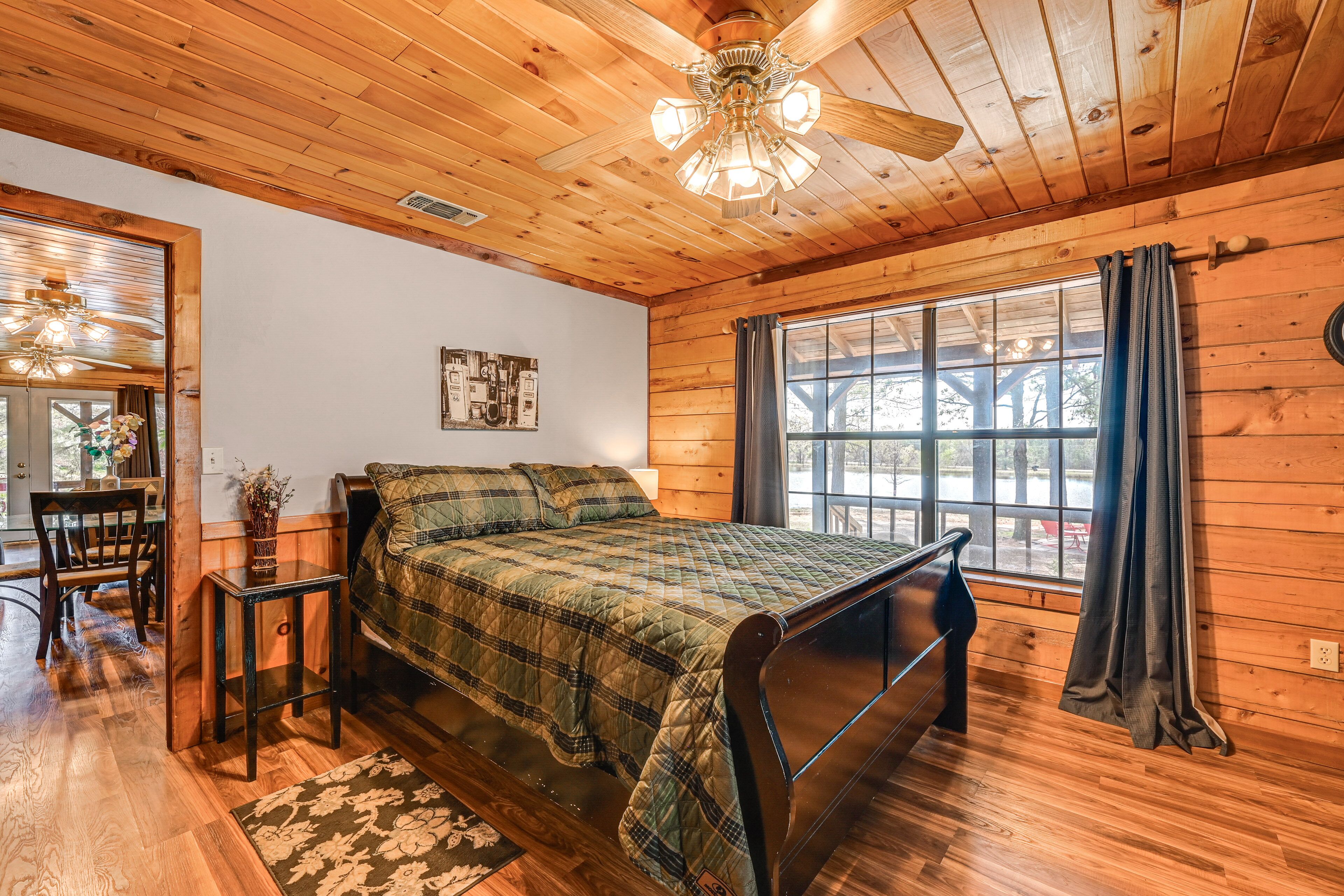 Une chambre dans une cabane en bois, avec un lit, une petite table et une chaise.