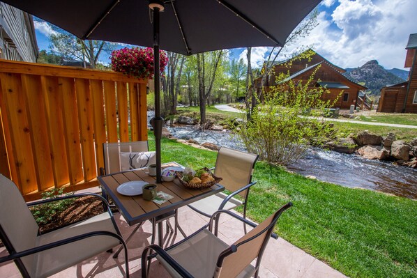 An outdoor patio with a table, chairs, and a large umbrella. - On the River, Downtown Estes Park, Close to RMNP Entrance (Estes Park)