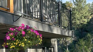 A two-story house with a balcony, a stone facade, and a hanging flower basket. - On the River, Downtown Estes Park, Close to RMNP Entrance (Estes Park)