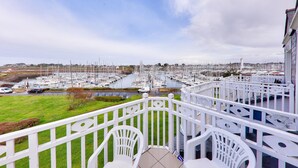 A balcony with white railings overlooking a marina filled with boats, a grassy area, and a clear sky. - Relaxation and harbour views in Arzon - Pool (Arzon)