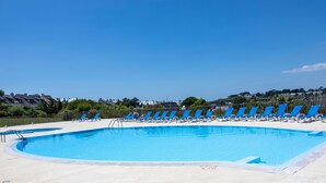 A swimming pool with blue lounge chairs and a clear sky. - Relaxation and harbour views in Arzon - Pool (Arzon)