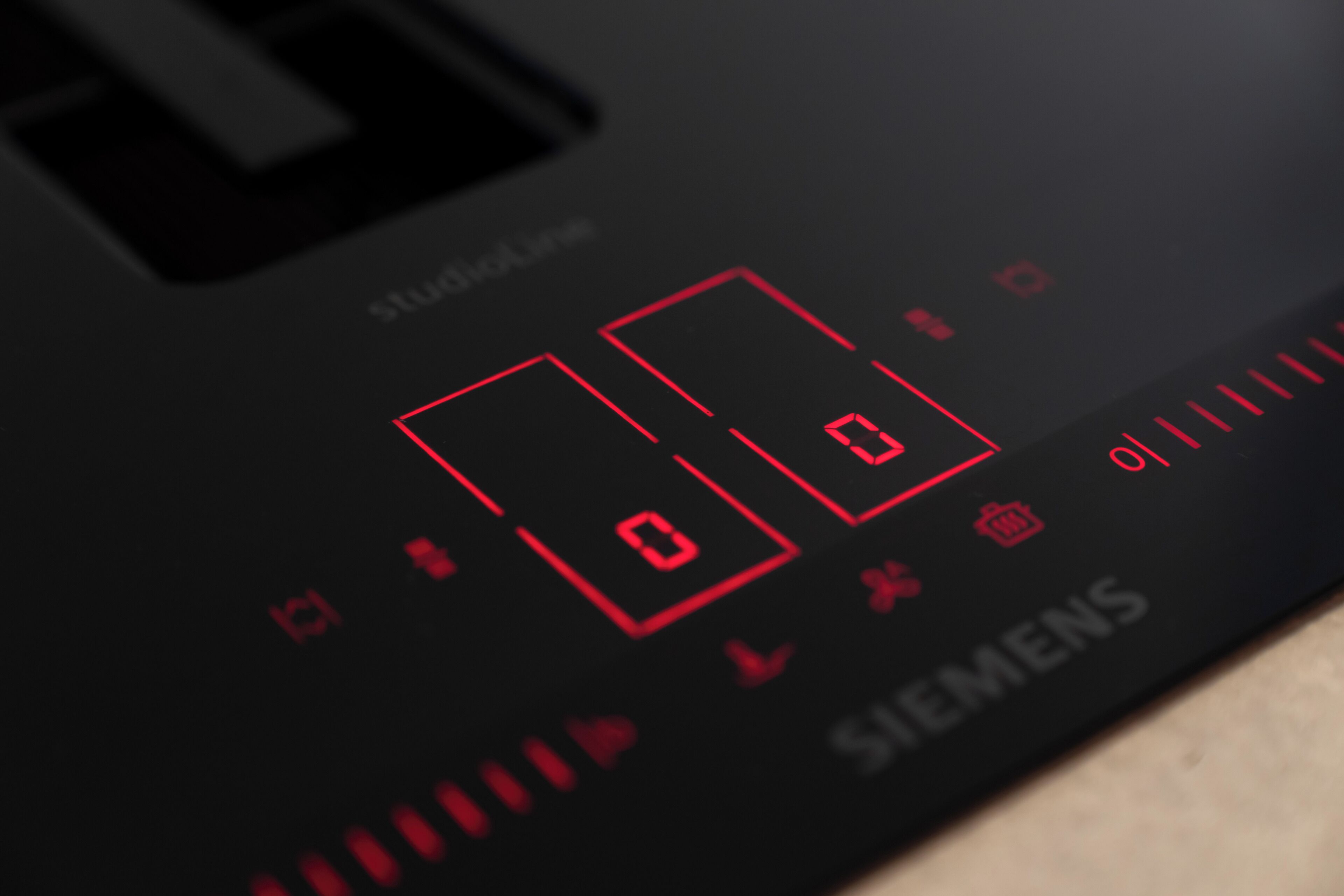 A close-up of a black control panel with red digital displays and the Siemens logo.