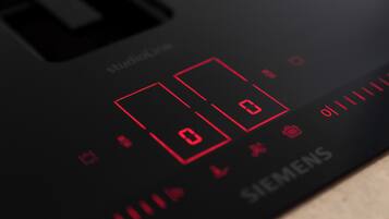 A close-up of a black control panel with red digital displays and the Siemens logo.