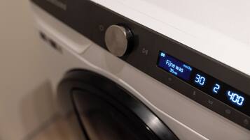 Een wasmachine met een digitaal scherm dat een wasprogramma van 30 minuten aangeeft.