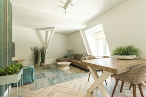 Ein modernes Loft mit Essbereich, Sitzgelegenheiten und Topfpflanzen.