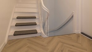 Un escalier avec une rampe blanche et des marches en bois.