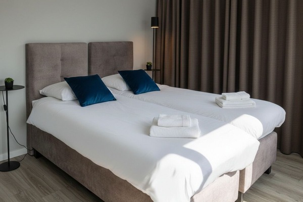 Bright bedroom with cozy linens and blackout curtains — your peaceful base in Raamsdonksveer, Noord-Brabant.