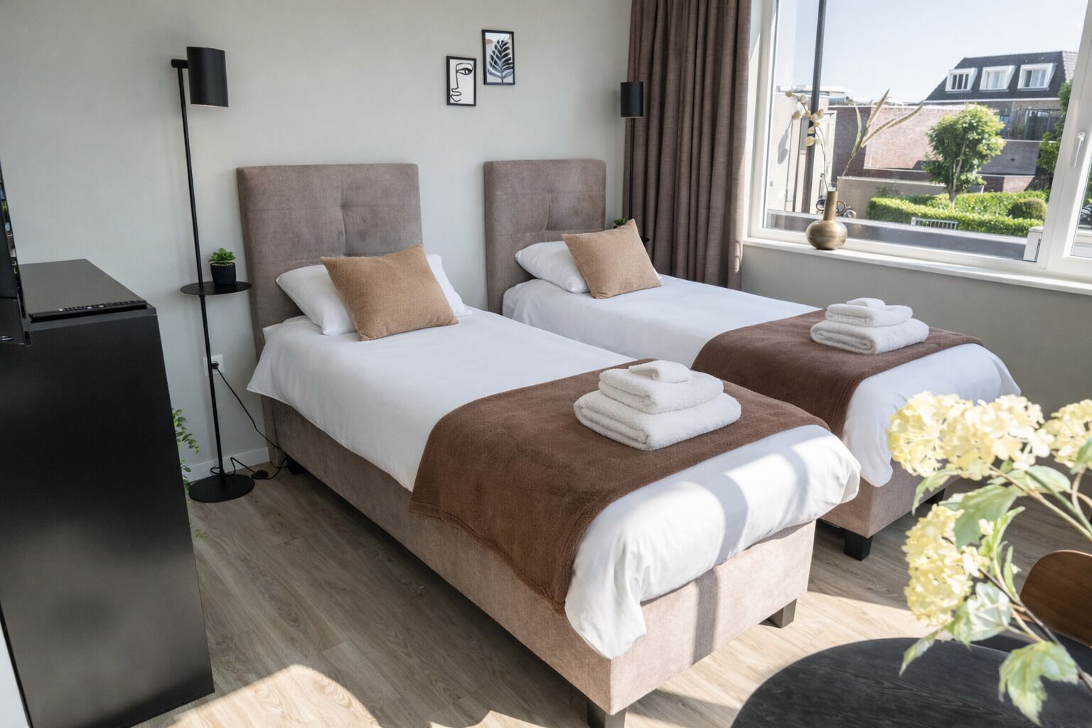 A bright and modern twin bedroom featuring two comfortable single beds (90x200 cm) that can be kept separate or easily pushed together to create a larger double bed. The room is ideal for two guests, perfect for friends, colleagues, or couples.