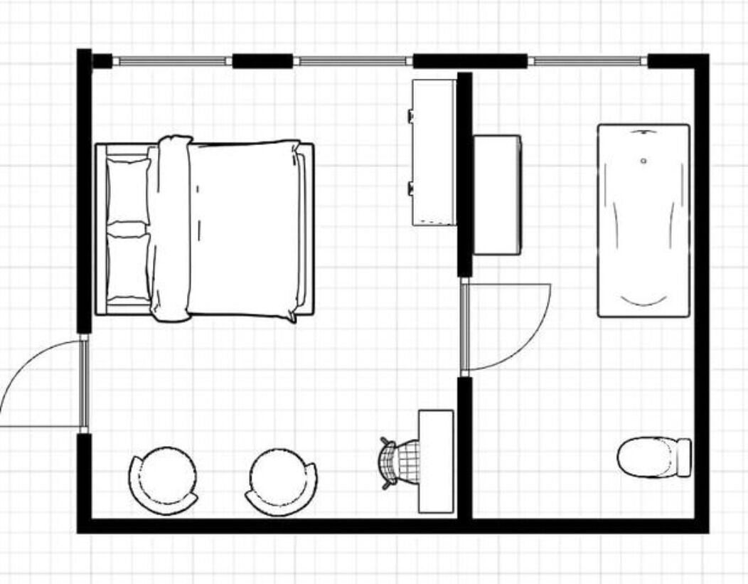 Een plattegrond van een hotelkamer met een bed, een bureau, een stoel, een toilet en een wastafel.