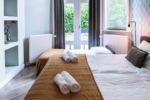 Habitació d'hotel amb un llit, una catifa marró i dues tovalloles arremolinades damunt el llit.