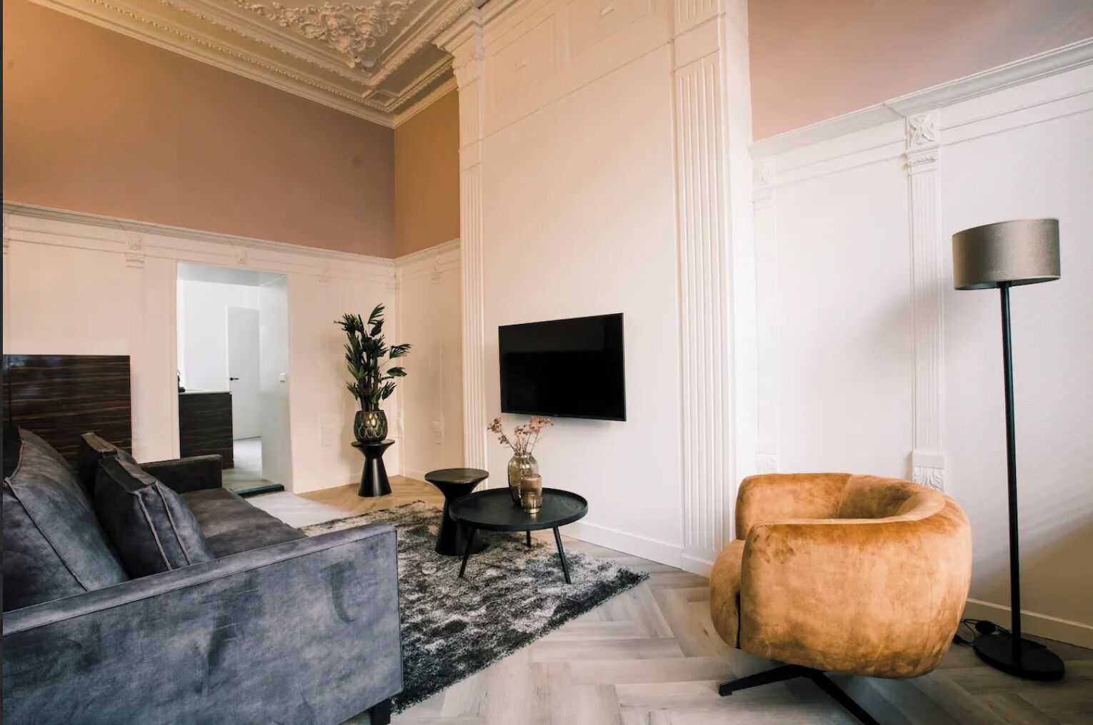 Un salon moderne comprenant un canapé, un fauteuil et une petite table ronde agrémentée d’objets décoratifs.