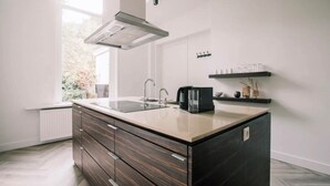 Una cocina moderna con una isla central, horno empotrado y ventana que proporciona luz natural.