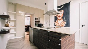 Una cocina moderna con una isla central, electrodomésticos integrados y un amplio ventanal.