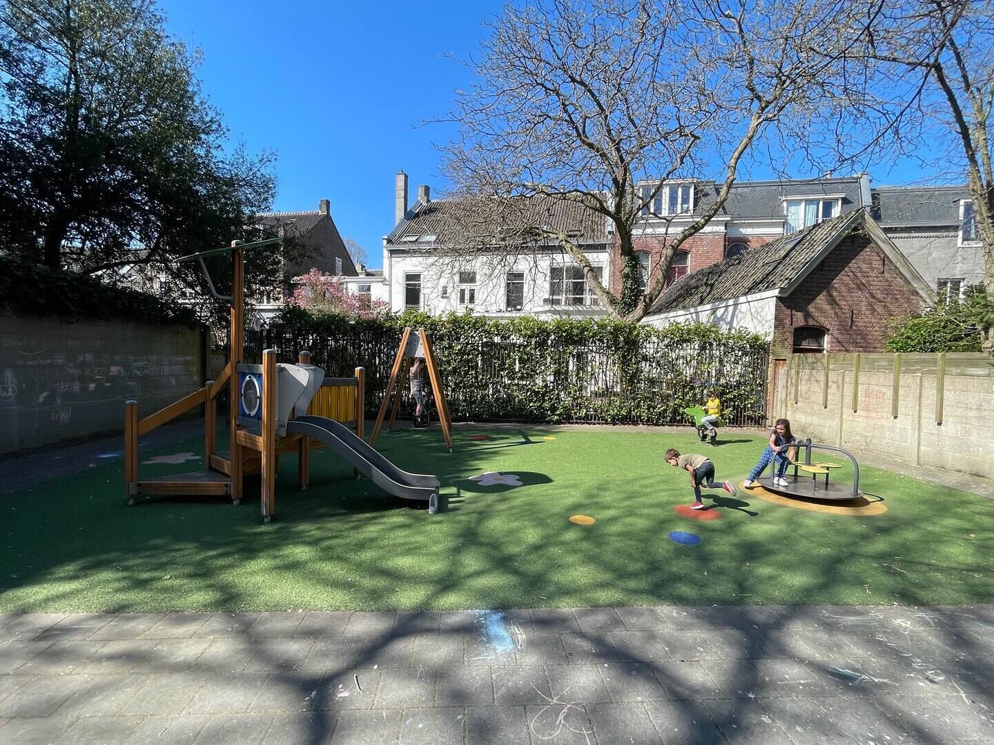 Une aire de jeux avec un toboggan, des balançoires et une structure d’escalade.