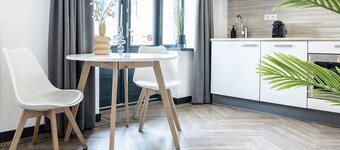 Estudio moderno con cocina, baño privado y dos balcones, ubicado en un edificio histórico.