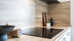 A modern kitchen with a wooden countertop, a black induction cooktop, and a small potted plant. - Unwind in a contemporary, newly renovated single room, conveniently located in central Tilburg (Tilburg)