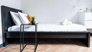 A modern bedroom with a bed, a small table, a potted plant, and a nightstand. - Unwind in a contemporary, newly renovated single room, conveniently located in central Tilburg (Tilburg)
