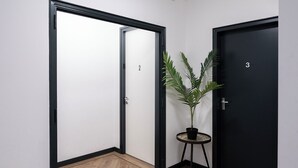 A hallway with two doors, one labeled '2' and the other '3', and a potted plant on a small table. - Unwind in a contemporary, newly renovated single room, conveniently located in central Tilburg (Tilburg)
