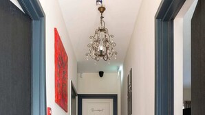 Un pasillo con piso estampado, un candelabro y una puerta que dice "Brandenburg".