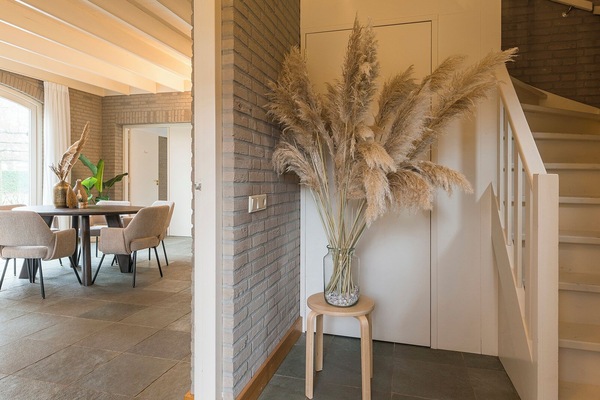 Elegant entryway accented with natural textures and soft, ambient lighting, creating a warm welcome into the spacious dining area.