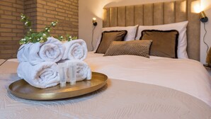 A neatly made bed with rolled white towels, a tray with a bottle, and a decorative plant. - Spacious countryside stay near Boxtel with lake views, free parking and fast Wi-Fi. Quiet, comfortable and perfect for a relaxing getaway. (Boxtel)