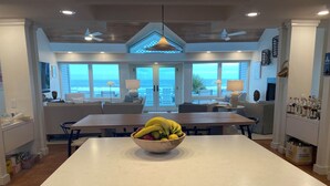 A modern kitchen with a central island, large windows, and a view of the ocean. - Stunning Oceanfront Home with Private Beach Access - 468 Tarpon (Fripp Island)