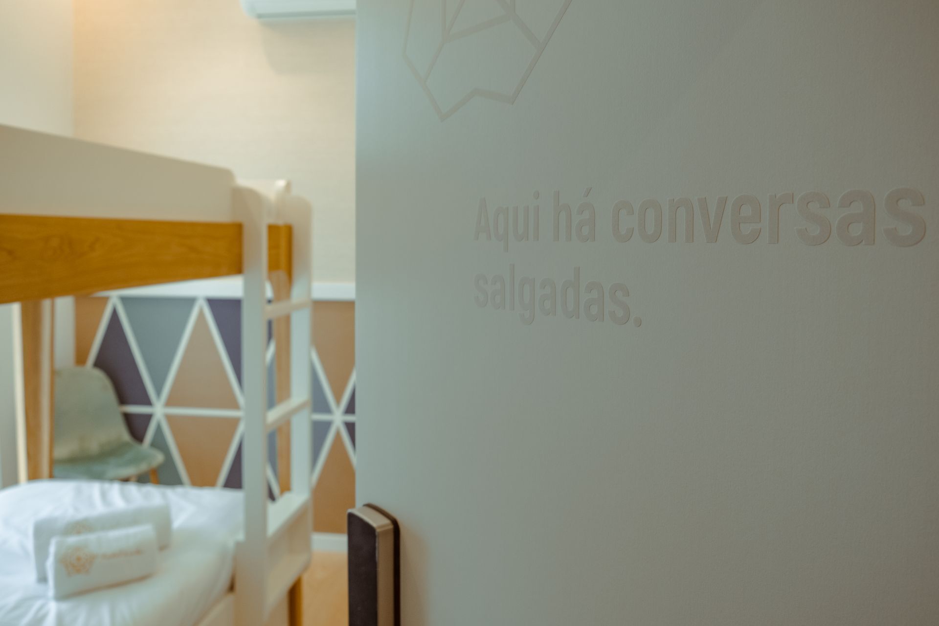 Una habitación con una cama litera y una pared blanca con texto.