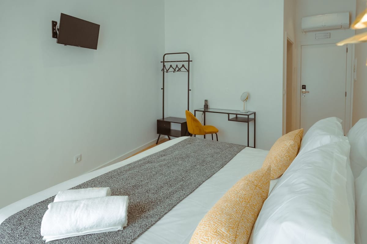 Ein Hotelzimmer mit Bett, Schreibtisch, Stuhl und Garderobe.