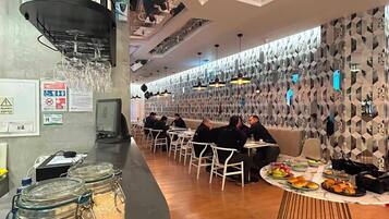 Un restaurante moderno con mostrador curvo, zona de asientos y paneles decorativos en la pared.