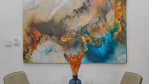 A dining table with two chairs, a vase, and a large abstract painting on the wall. - Diamond Apt - Simply awesome (Lekki)