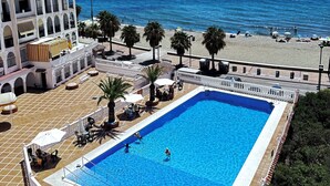 A swimming pool with clear blue water, surrounded by a white fence and palm trees. - Beautiful Place With Endless sea View (Fuengirola)