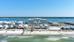 Ett hotell vid stranden med flera byggnader, en sandstrand och en brygga som sträcker sig ut i vattnet.