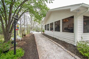A house with a covered porch, a gravel pathway, and a bench. - The Legacy at DeGray (Bismarck)