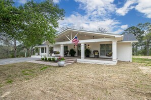 A single-story house with a covered porch, a flag, and a well-maintained lawn. - The Legacy at DeGray (Bismarck)