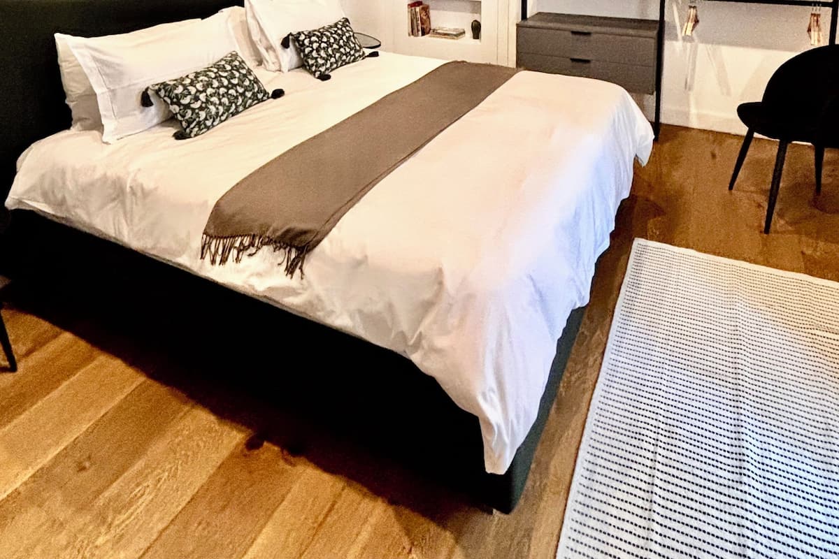 A bedroom with a bed, a desk, a chair, and a bookshelf.