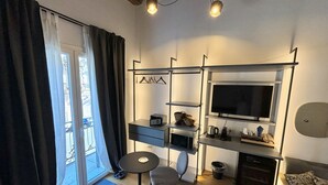 Un espace de vie compact comprenant un téléviseur, un petit bureau et une chaise.