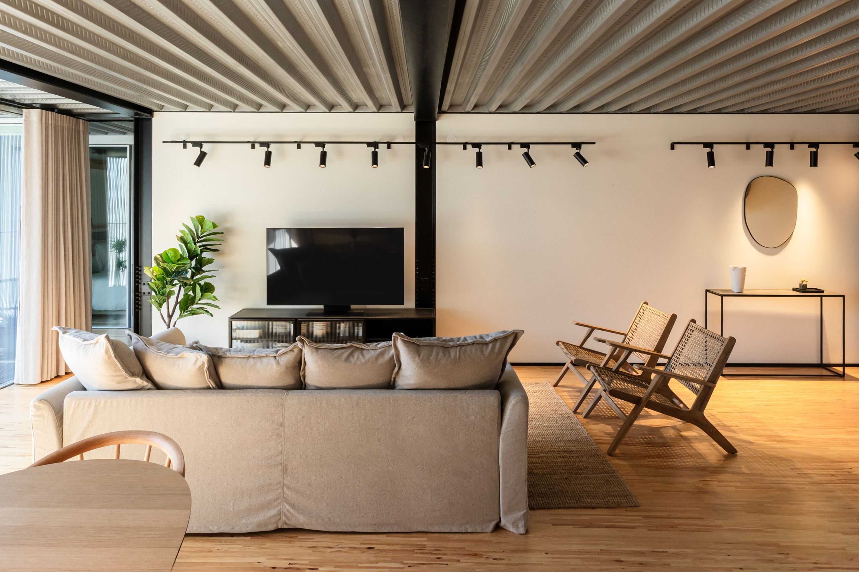 Una sala de estar moderna con sofá, televisor y zona de estar.