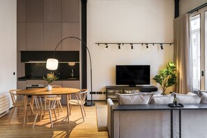 Ett modernt vardagsrum med en matplats, en platt-TV och ett stort fönster.