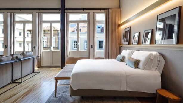 A hotel room with a bed, bedside table, desk, and large windows. - Feel Porto Matosinhos City Flat III (Matosinhos)