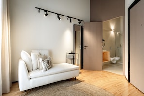 A modern living room with a sofa, a small table, and a mirror. - Feel Porto Matosinhos City Flat V (Matosinhos)