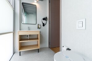 A modern bathroom with a wooden vanity, a mirror, a hairdryer, and a toilet paper holder. - Feel Porto Matosinhos City Flat II (Matosinhos)