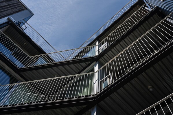 A multi-level building with a modern architectural design, featuring balconies with metal railings and large windows. - Feel Porto Matosinhos City Flat I (Matosinhos)