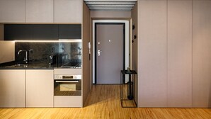 Eine moderne Küche mit integrierten Geräten, Holzboden und einer Tür zu einem weiteren Raum.