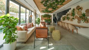 A modern interior with a sofa, chairs, a dining area, and a ceiling garden. - Twin room in Private villa (Dubai)