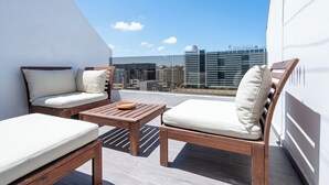 A rooftop terrace with two wooden lounge chairs and a small table, offering a view of the city skyline. - Cozy Studio Near Train Stations & Hassan II Mosque (Casablanca)